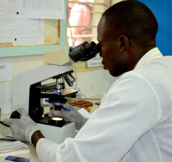 A laboratory technician at a microscope