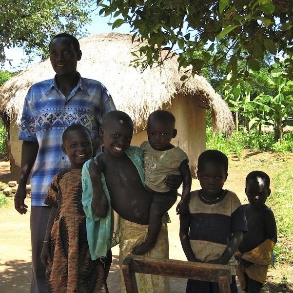 A farming family outside their home